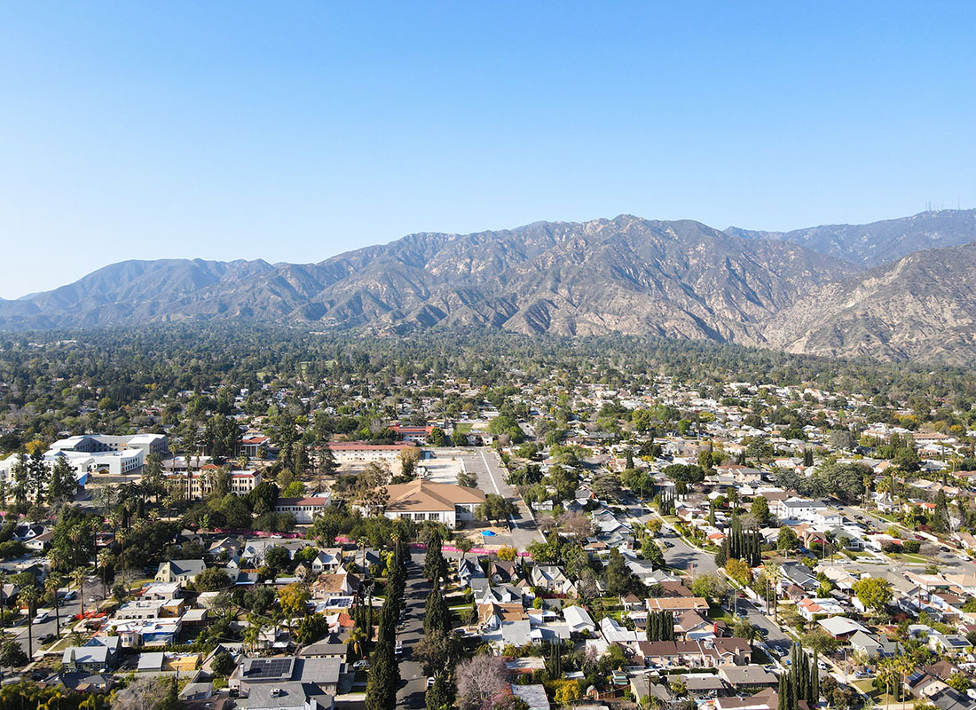 Pasadena, CA - Aerial View of Homes and Businesses in the Valley of Pasadena California with Mountains in the Background
